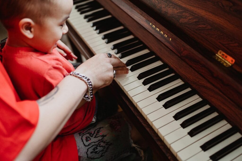 Enfant et adulte jouent du piano ensemble.