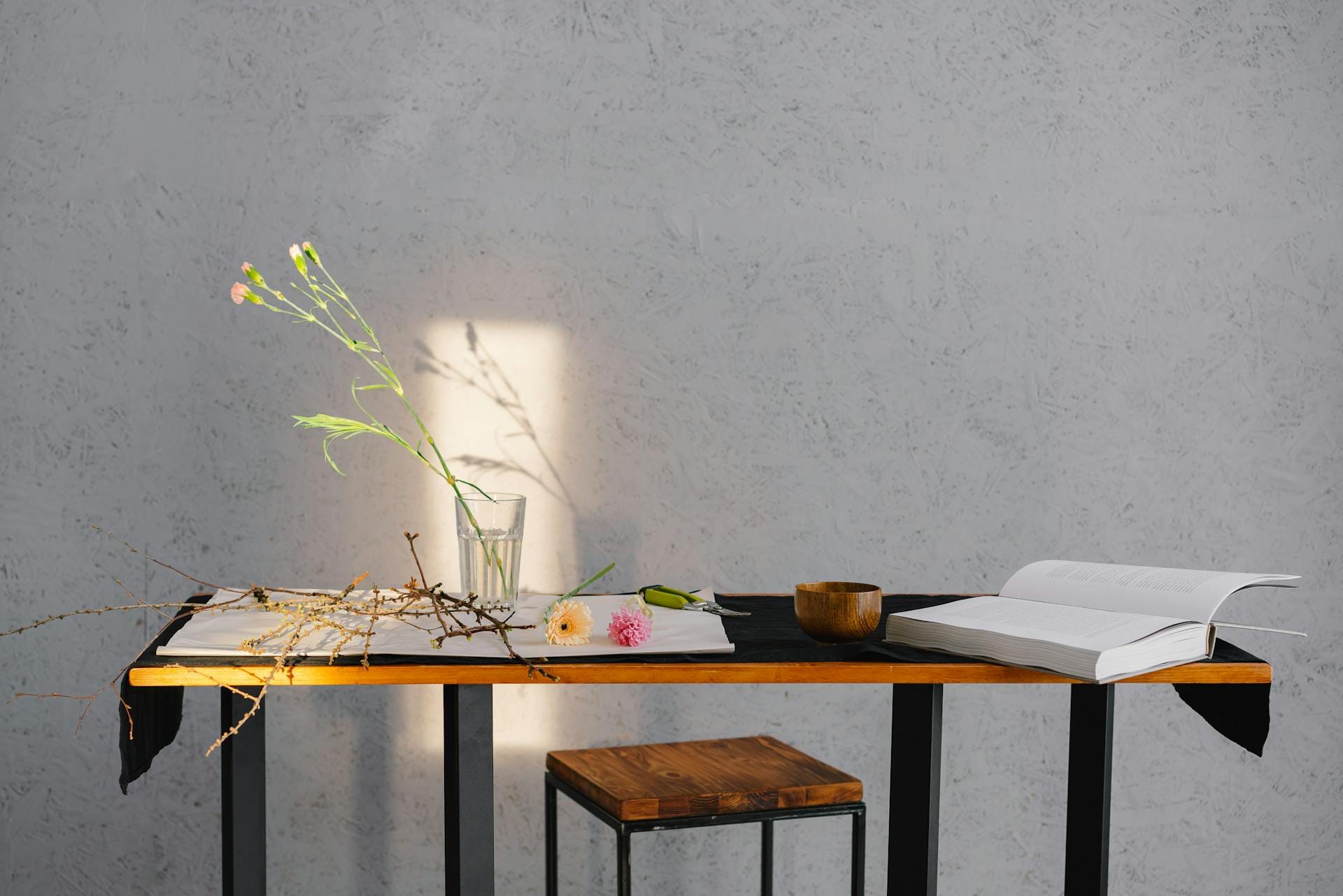 Table avec livre, fleurs et branches.