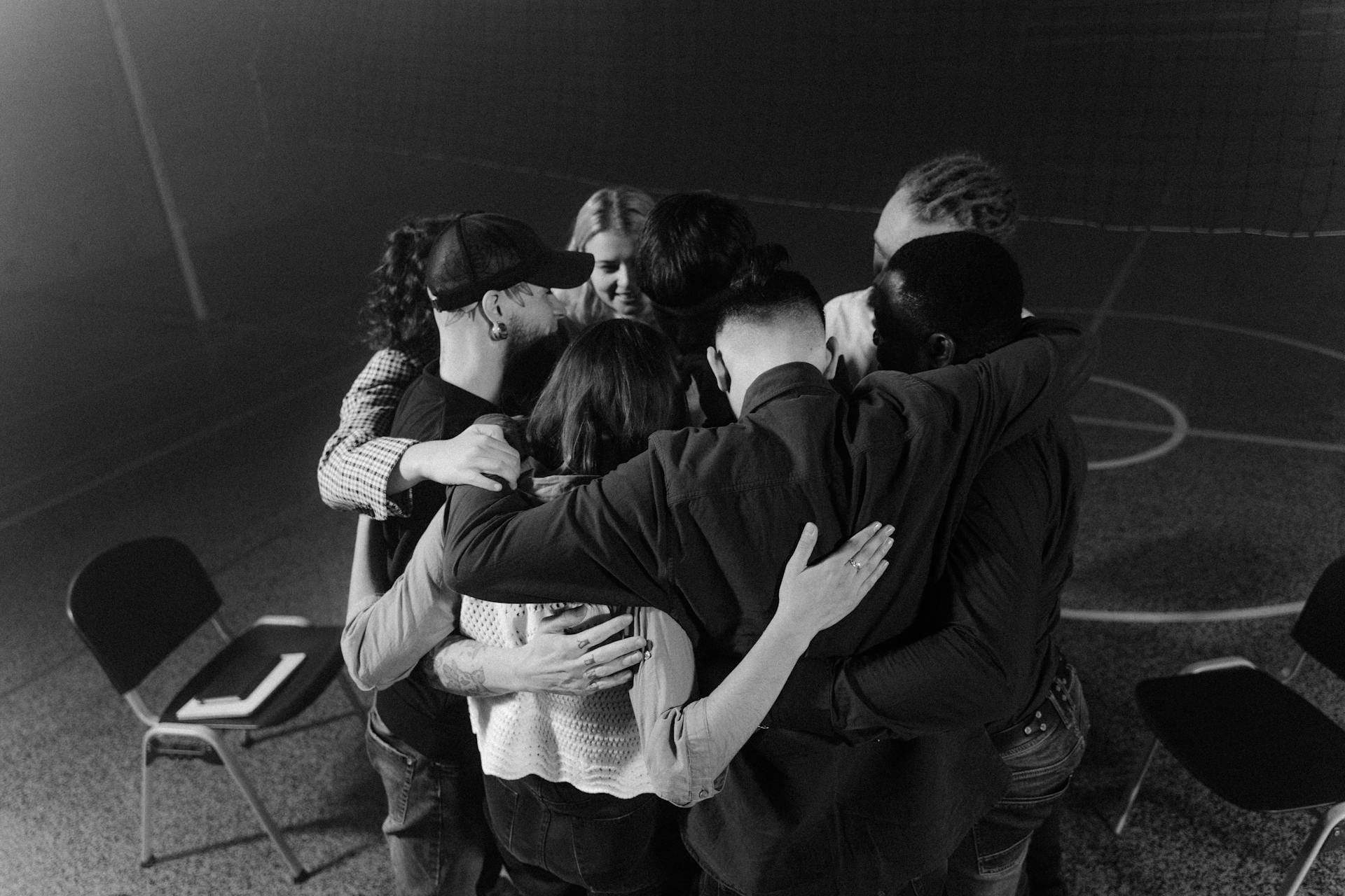 Groupe s'enlaçant en cercle sur un terrain.