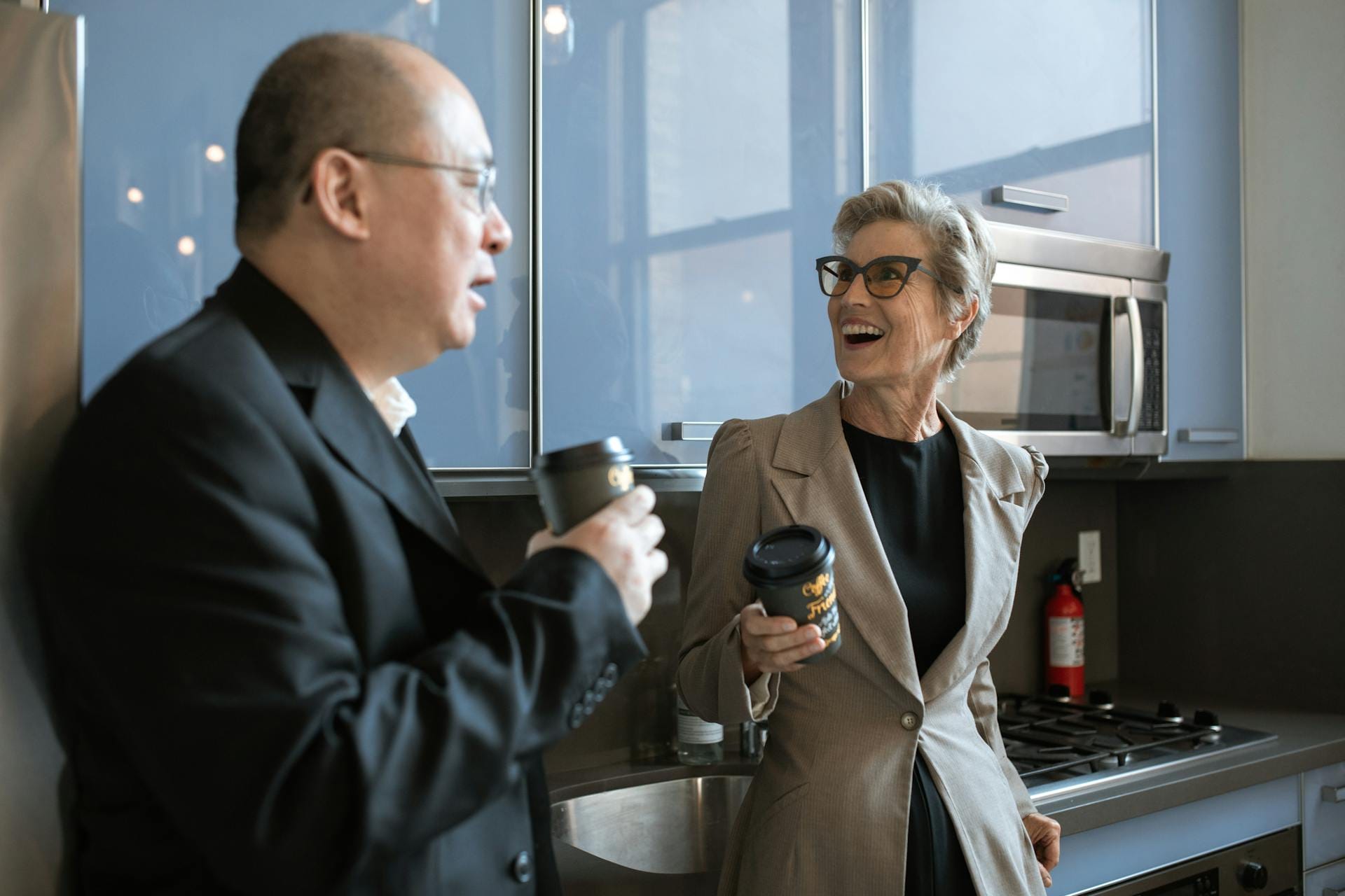 Deux personnes discutent avec des cafés.