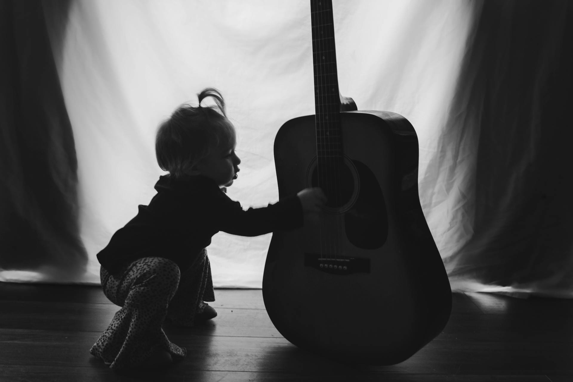 Enfant jouant avec une guitare acoustique.