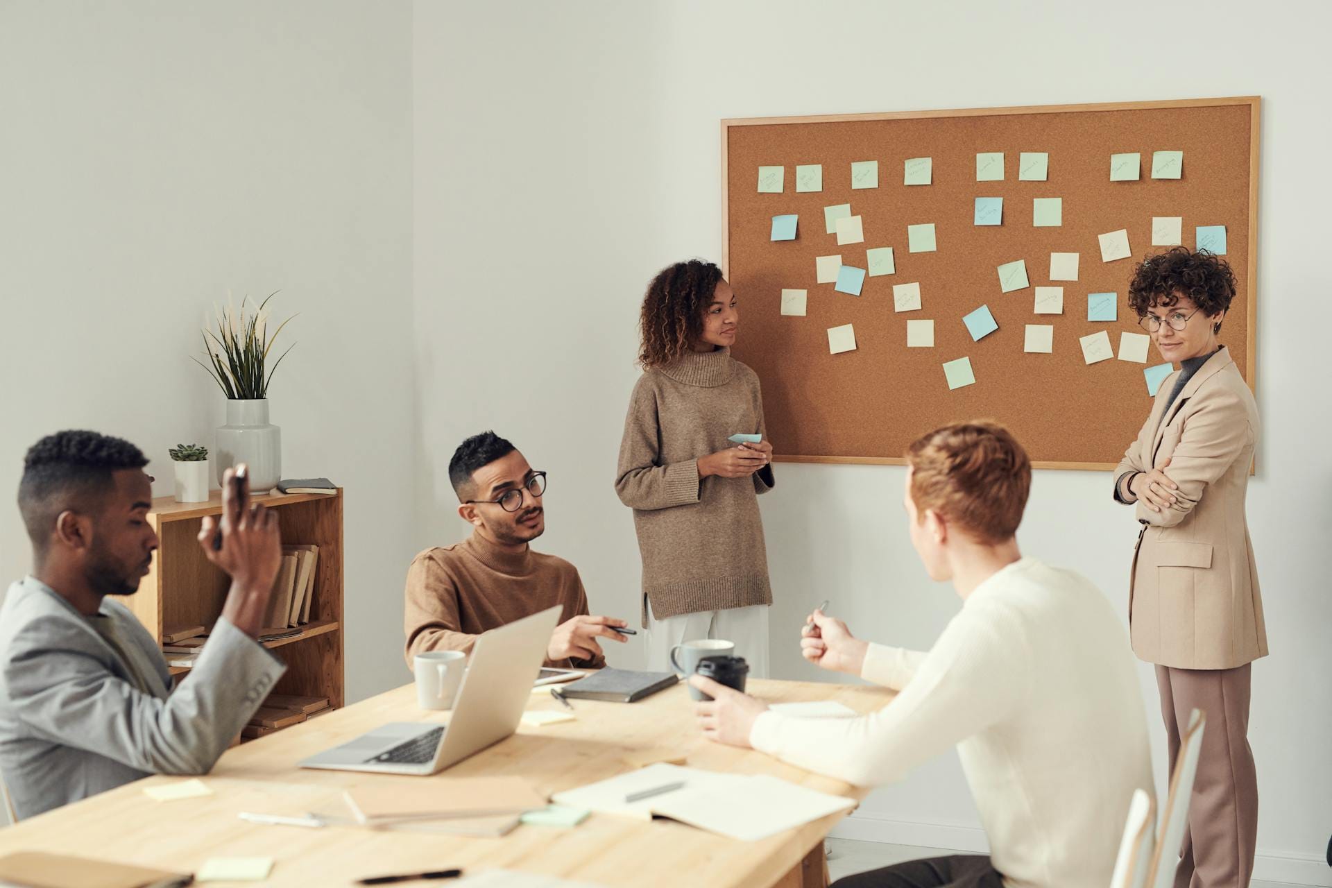 Réunion d'équipe devant tableau avec post-it.