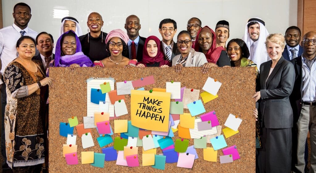 Personnes souriantes devant un panneau de motivation.