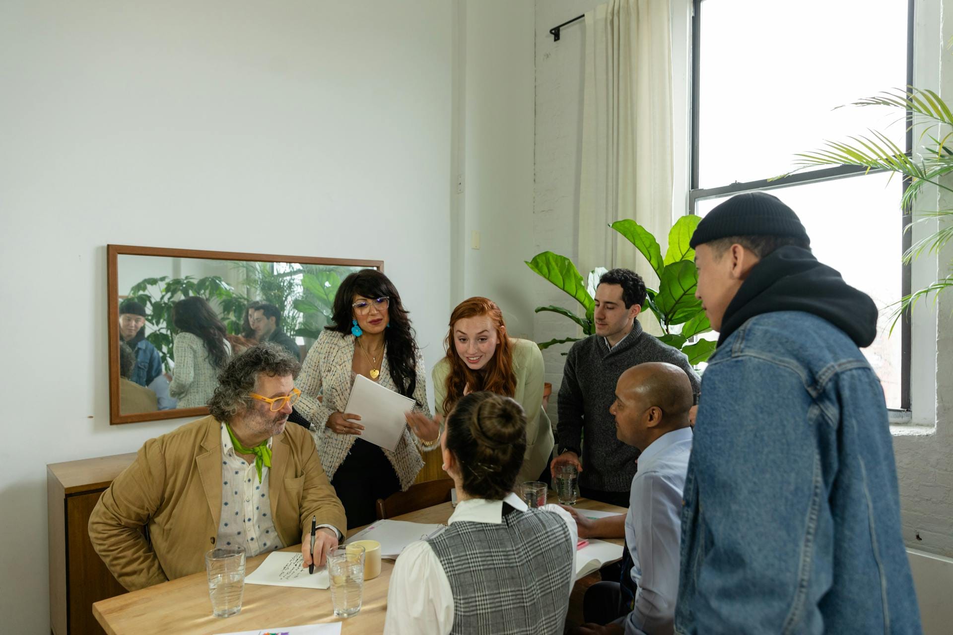 Groupe discutant autour d'une table, réunion professionnelle.